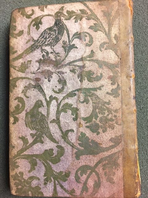Brocade paper binding with gold birds and leaves on a red ground faded to pink